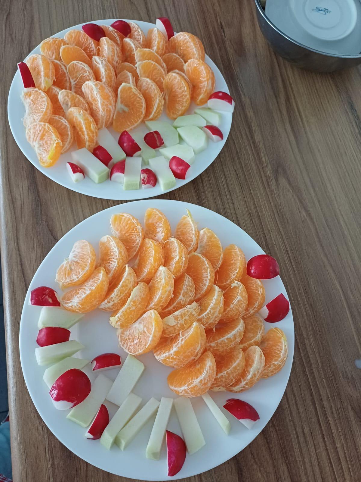 Zdjęcie talerza z mandarynkami, kalarepą i rzodkiewką